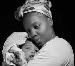 Illustration of African motherhood symbols: stylized representations of a Maasai cow, Bakongo Phemba mother-and-child figure, and Adinkra-inspired motifs, symbolizing protection, fertility, ancestral wisdom, and maternal love.