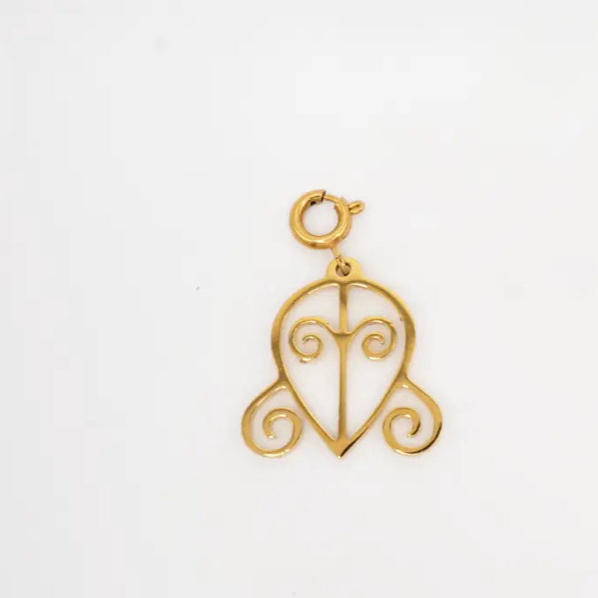 Gold heart-shaped pendant with intricate design on a white background. Adinkra Odo Nnyew Fie Kwan symbol. 