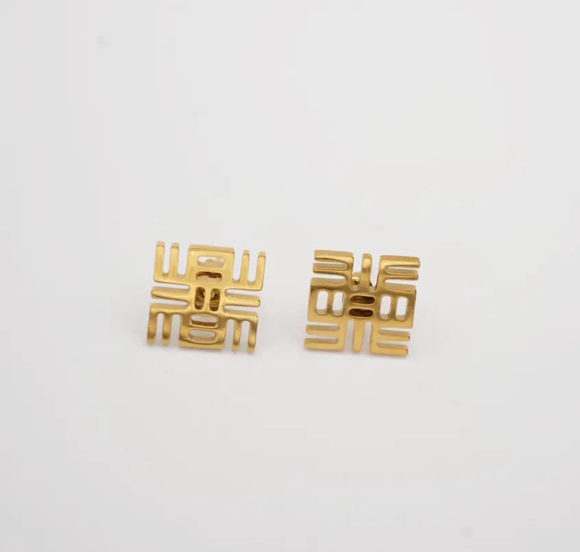 Gold earrings with a geometric design on a white background