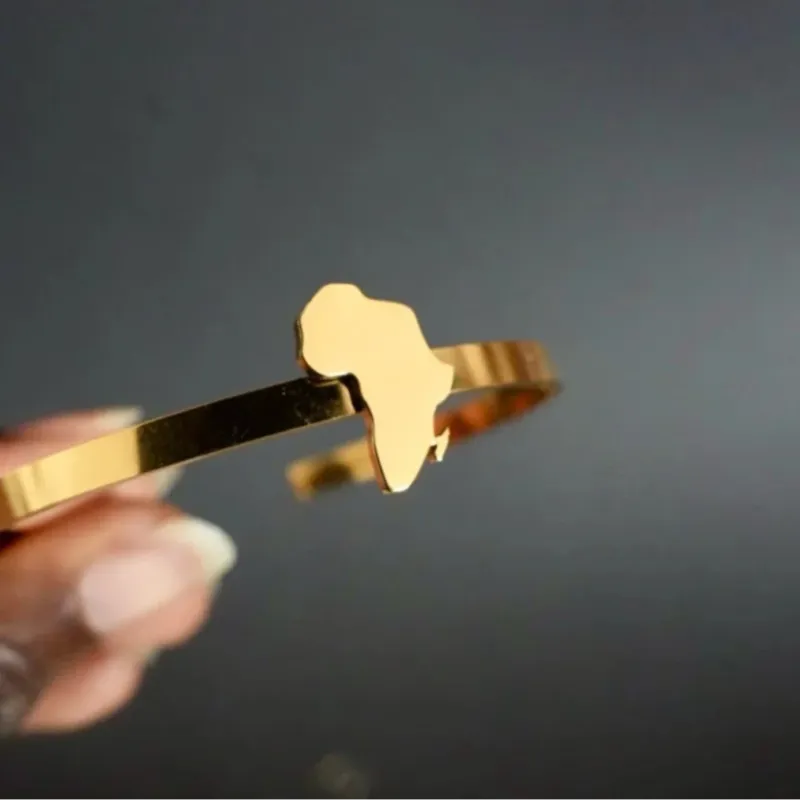 Alkebulan Bangle – gold metal cuff bracelet featuring a cut-out African continent map, minimalist and elegant design, lightweight and symbolic, perfect for everyday wear and cultural pride.