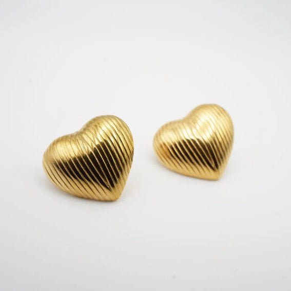 Gold heart-shaped earrings on a white background