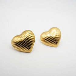 Gold heart-shaped earrings on a white background