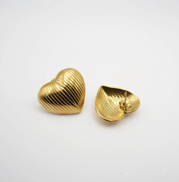 Gold heart-shaped earrings on a white background