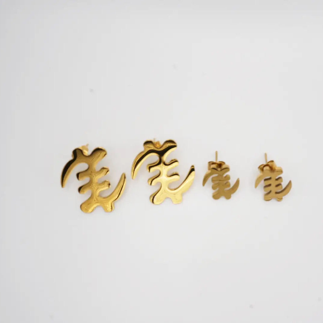 Gold earrings with akan characters on a white background