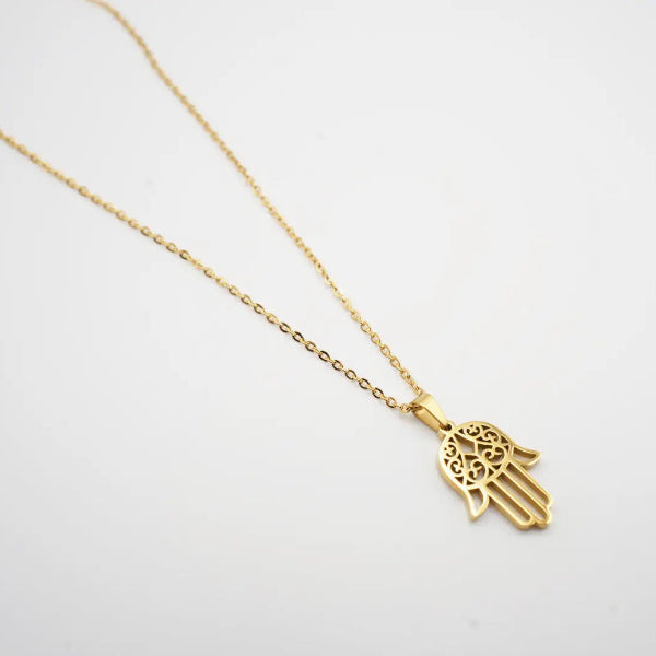 Gold Hamsa hand necklace on a white background