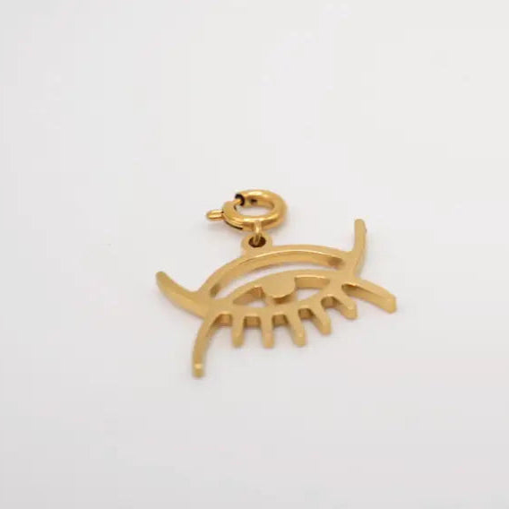 Gold eye-shaped pendant on a white background. Adinkra symbol Abode Santann, this charm honor the vastness and unity of existence