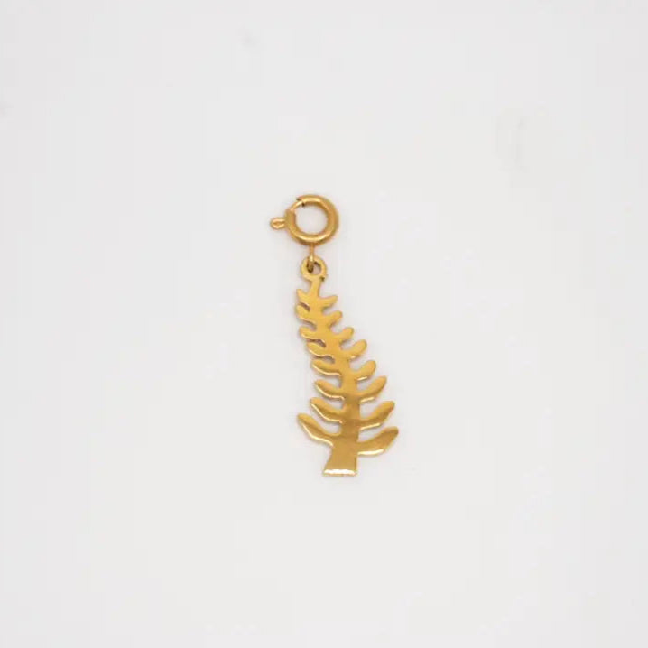 Gold leaf-shaped adinkra charm on a white background