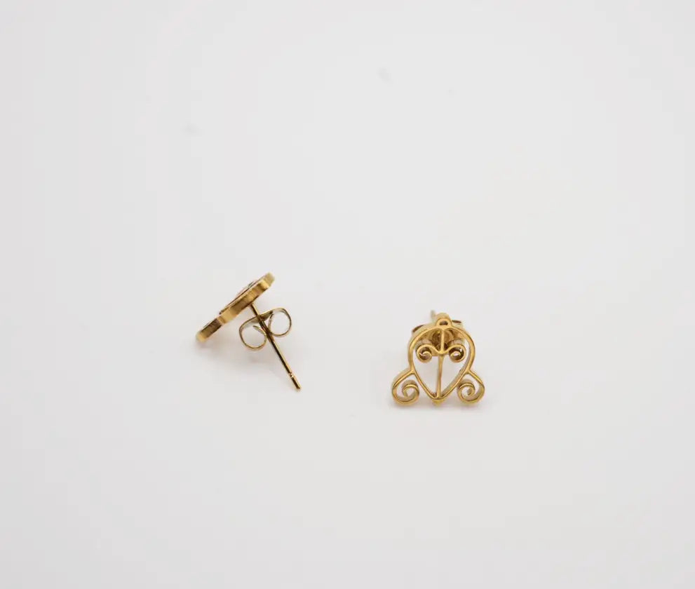 Gold earrings on a light gray background