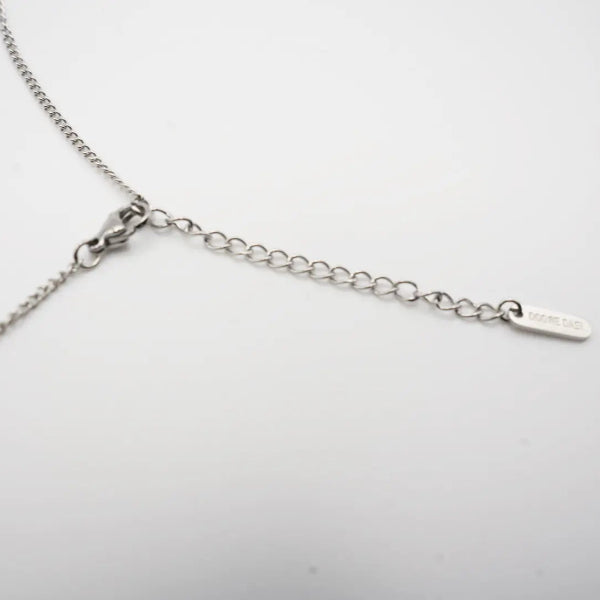 Silver necklace on a light gray background