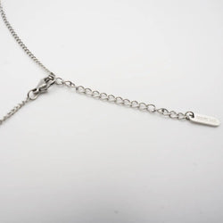 Silver necklace on a light gray background