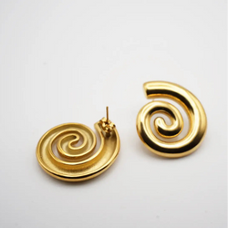 Gold spiral earrings on a light gray background