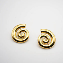 Gold spiral earrings on a light gray background