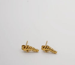 Gold skeleton bone-shaped earrings on a light gray background