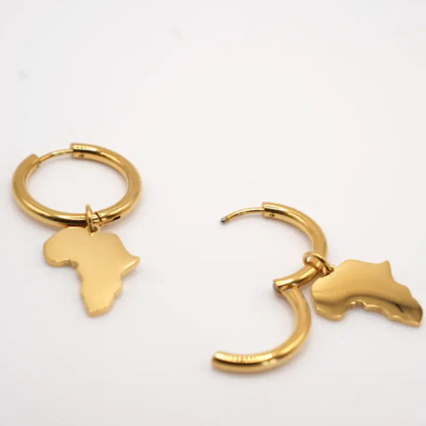 Gold earrings shaped like Africa on a white background