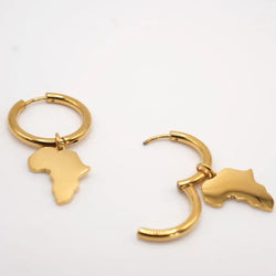 Gold earrings shaped like Africa on a white background