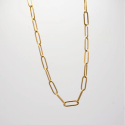 Gold chain necklace on a light gray background