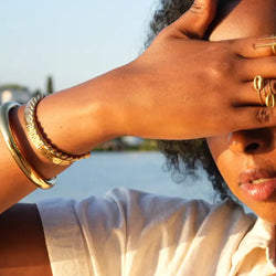 Woman shielding her eyes from the sun with a scenic background