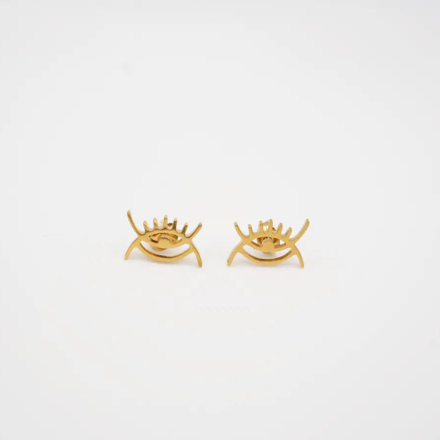 Gold eye-shaped earrings on a light gray background from adinkra symbols 