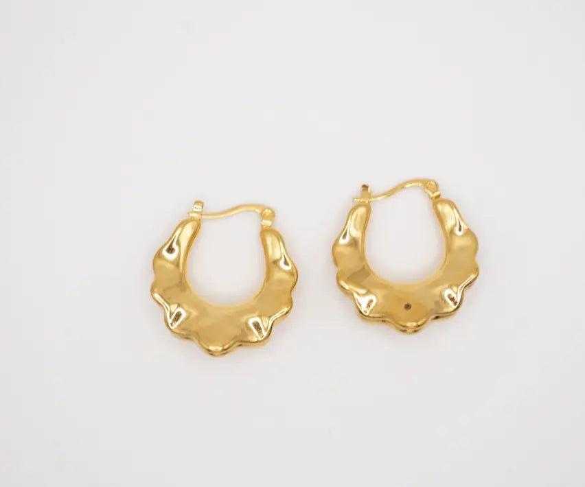 Gold hoop earrings on a light gray background