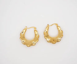 Gold hoop earrings on a light gray background