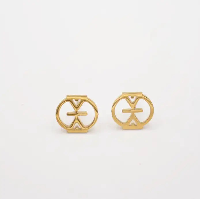 Pair of gold earrings with circular designs on a white background. Adinkra studs that means resilience