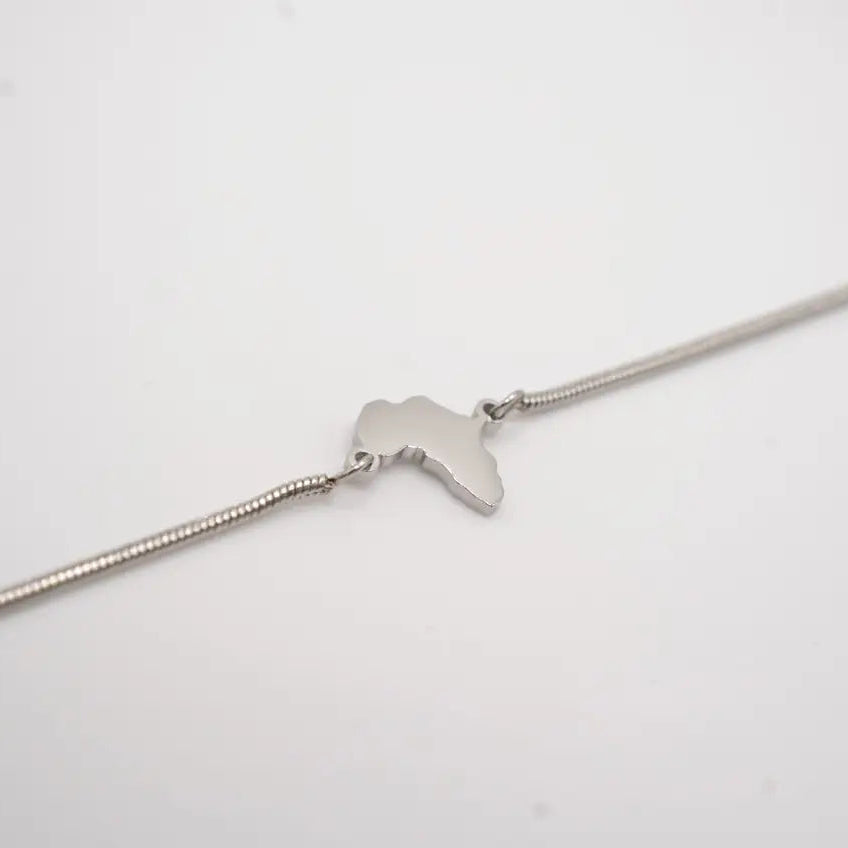 Silver bracelet with a small pendant on a light gray background