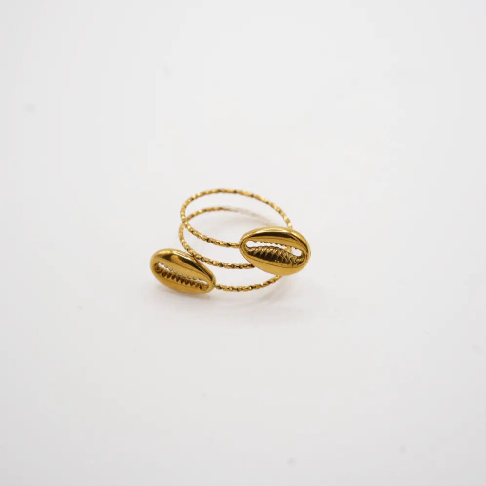 Gold ring with shell-like designs on a white background